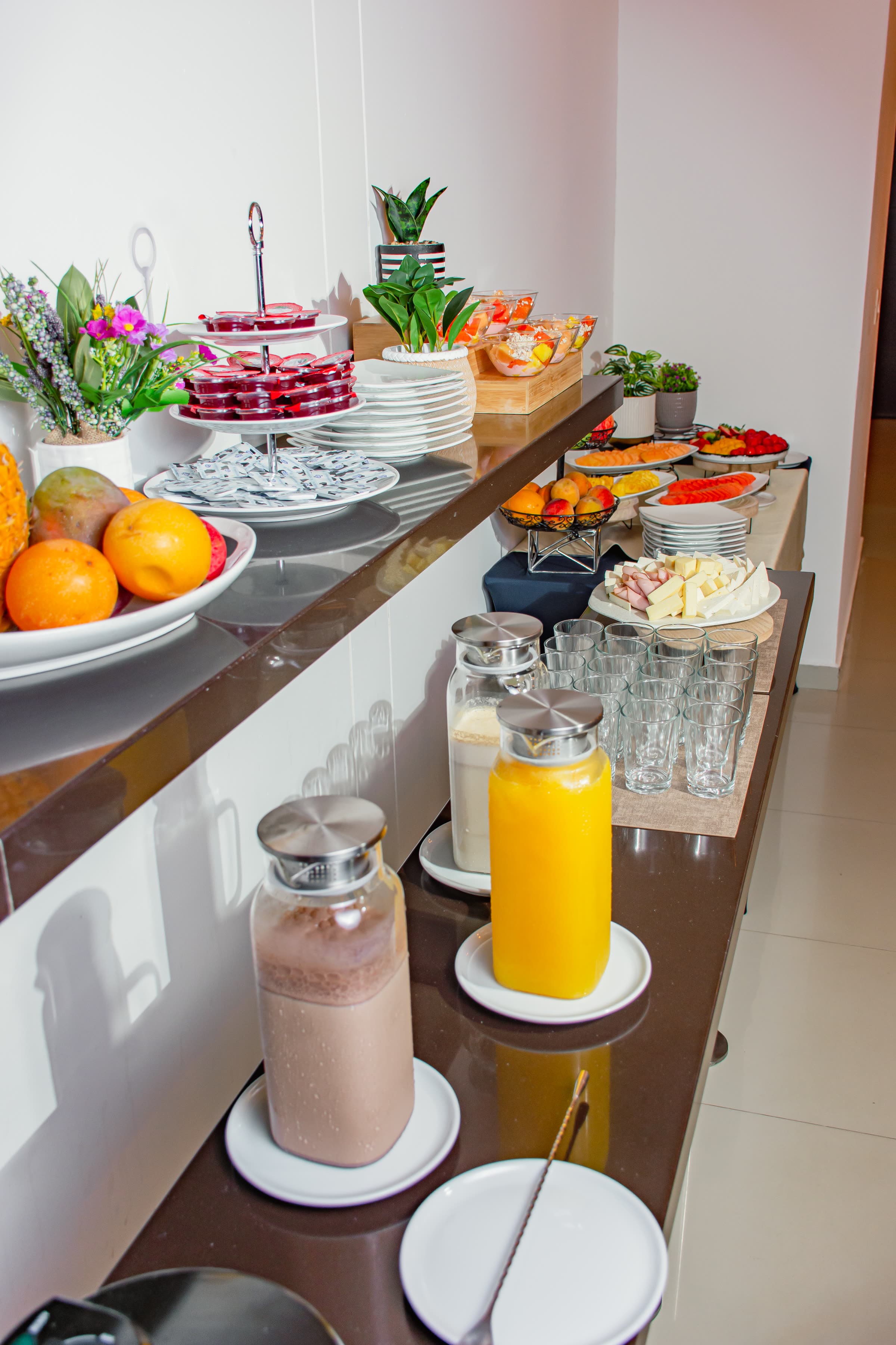 Buffet de desayuno con frutas, jugos y quesos