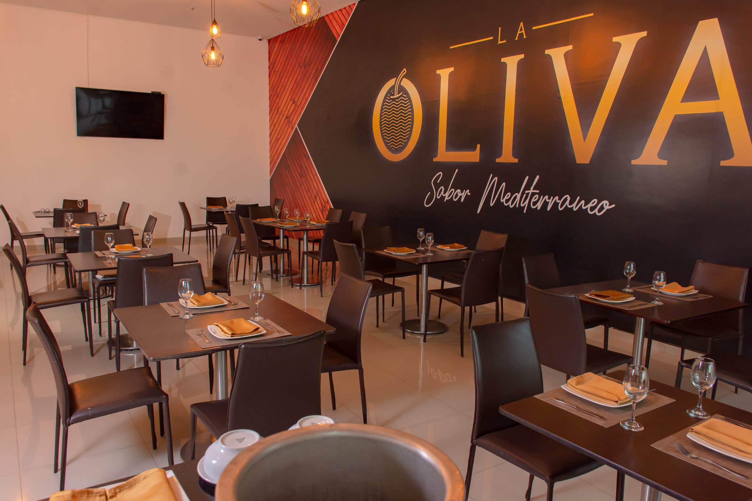 Salón del restaurante La Oliva con su muro negro y letras doradas