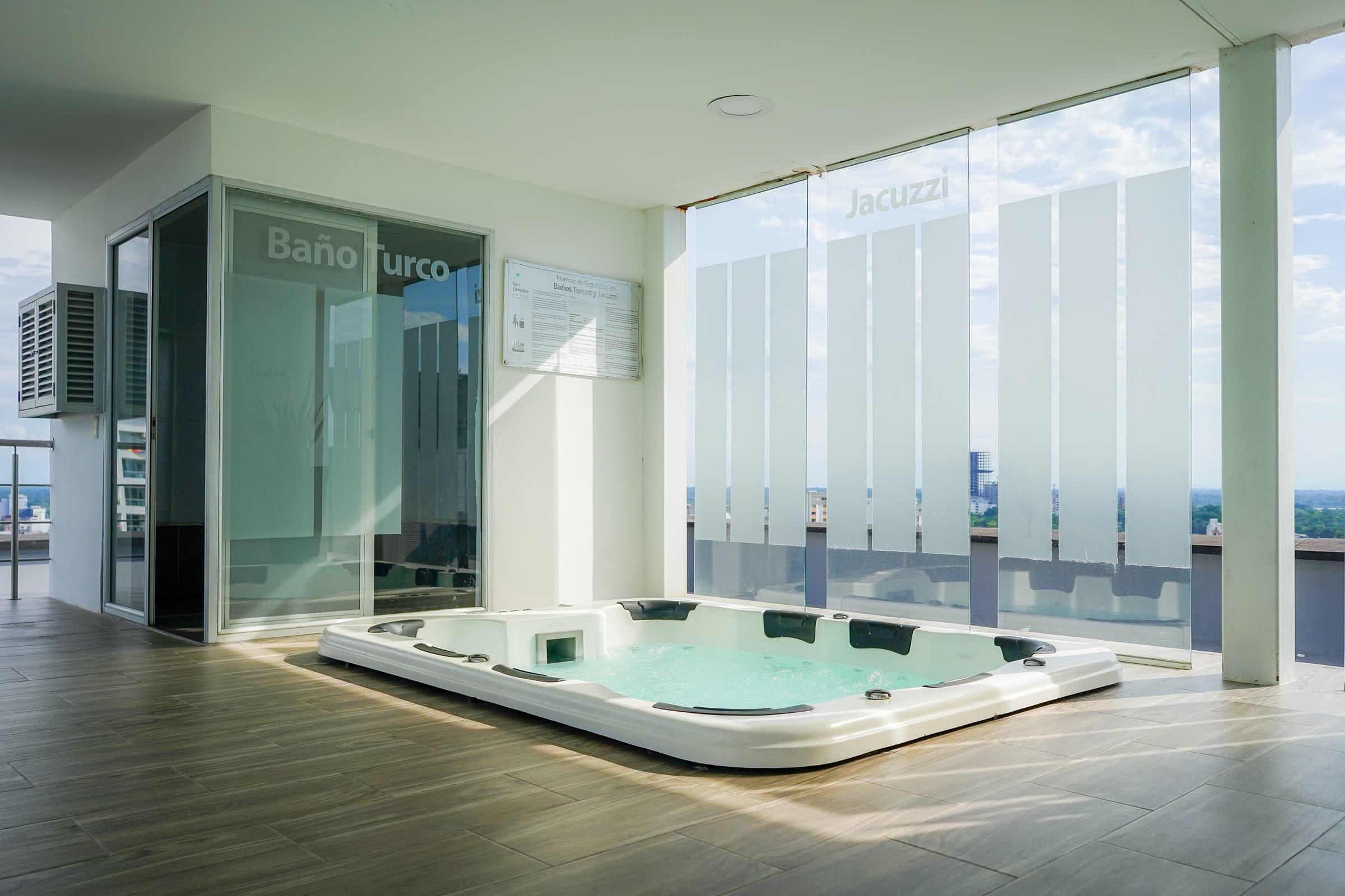 Zona húmeda del spa con jacuzzi y baño turco, iluminada por luz natural